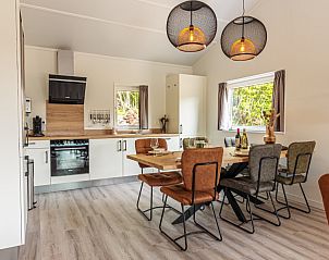 Ervaar de stijlvolle keuken en eetruimte van vakantiehuis Nesserduinen 42B in Nes, Ameland, ideaal voor gezellige maaltijden.