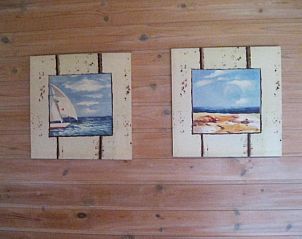 Kunstwerken aan de muur in Geertje-Aaltje bungalow, Nes, Ameland voor een huiselijke sfeer.