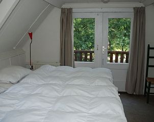 Comfortabele slaapkamer in vakantiehuis Krekel, Nes, Ameland met uitzicht op het groen van de Waddeneilanden.