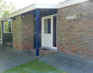 Ingang van vakantiehuis Skries in Nes, Ameland, met charmante bakstenen gevel.