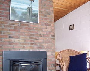 Gezellige woonkamer met open haard in bungalow Skries, Nes, Ameland.