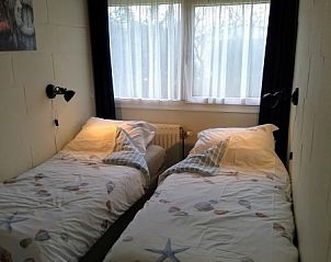 Slaapkamer met twee bedden in bungalow Skries, Nes, Ameland, met rustgevend uitzicht.