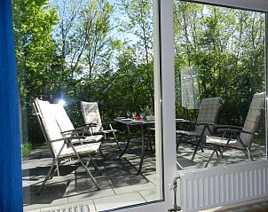 Zonnig terras van bungalow Skries in Nes, Ameland, perfect voor ontspanning.