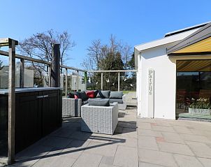 Gezellige zithoek op het terras van bungalow Patrijs in Nes, Ameland, ideaal voor buitenleven op de Waddeneilanden.