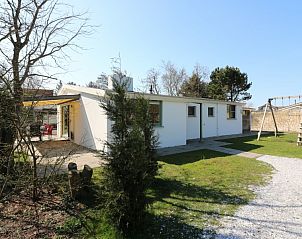 Achterzijde van bungalow Patrijs in Nes, Ameland, met speelruimte en groene omgeving op de Waddeneilanden.