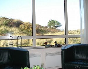 Uitzicht vanuit woonkamer Duinrust Nes Ameland met duinlandschap.