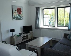 Gezellige zithoek in appartementenboerderij de Jong, Nes, Ameland, met uitzicht op de tuin.