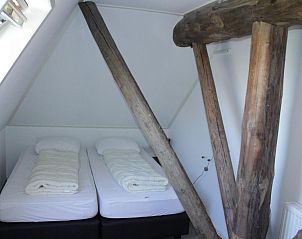 Knusse slaapkamer onder het dak in appartementenboerderij de Jong, Nes, Ameland.