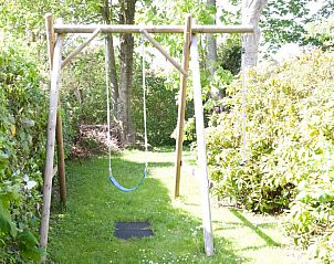 Speeltuin met schommel in tuin van Ascona bungalow, Nes, Ameland, ideaal voor familievakantie op de Waddeneilanden.
