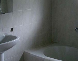 Ruime badkamer met bad in vakantiehuis Fazant, Nes, Ameland.