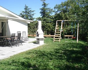 Tuin met speeltoestel en barbecue bij vakantiehuis Fazant, Nes, Ameland.