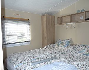 Ruime slaapkamer met tweepersoonsbed in de Cirkel chalet, Nes, Ameland, ideaal voor een ontspannen verblijf.