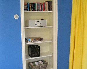 Boekenkast en entertainment in bungalow Derkina, Nes, Ameland voor ontspanning.
