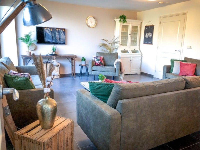 Gemuetliches Wohnzimmer im Unique 10 pers. Farm Lodge De Slufter in 'Hoeve Vianen', De Cocksdorp, Texel, mit bequemen Sofas.