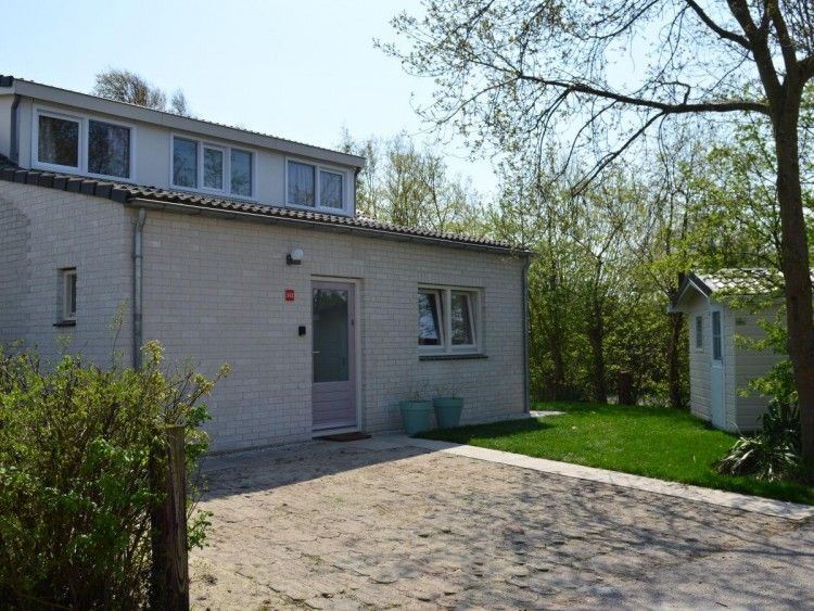 Bungalow 543 in De Cocksdorp, Texel biedt een charmante buitenkant omringd door groen, ideaal voor een ontspannen vakantie op de Waddeneilanden.