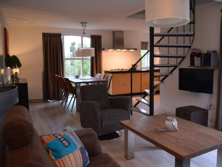 Comfortabele woonkamer in Bungalow 543, De Cocksdorp, Texel. Ontspan in een sfeervolle omgeving met open keuken en moderne inrichting.