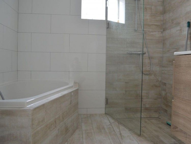 Moderne badkamer in Bungalow 543, De Cocksdorp, Texel. Luxe voorzieningen met inloopdouche en ligbad voor ultiem comfort.