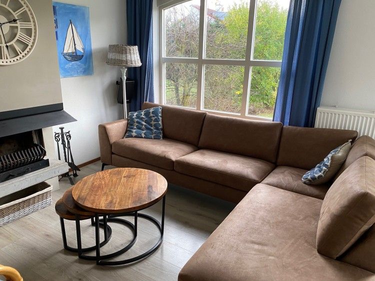 Cozy living room of Krim 661 with sauna, Stuha, and BBQ in De Cocksdorp, Texel. Comfortable bungalow with spacious sitting area and view of nature.