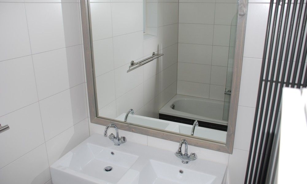 Modern bathroom in Krim 661 with sauna, Stuha, and BBQ, a bungalow in De Cocksdorp, Texel, with stylish sink and bathtub.
