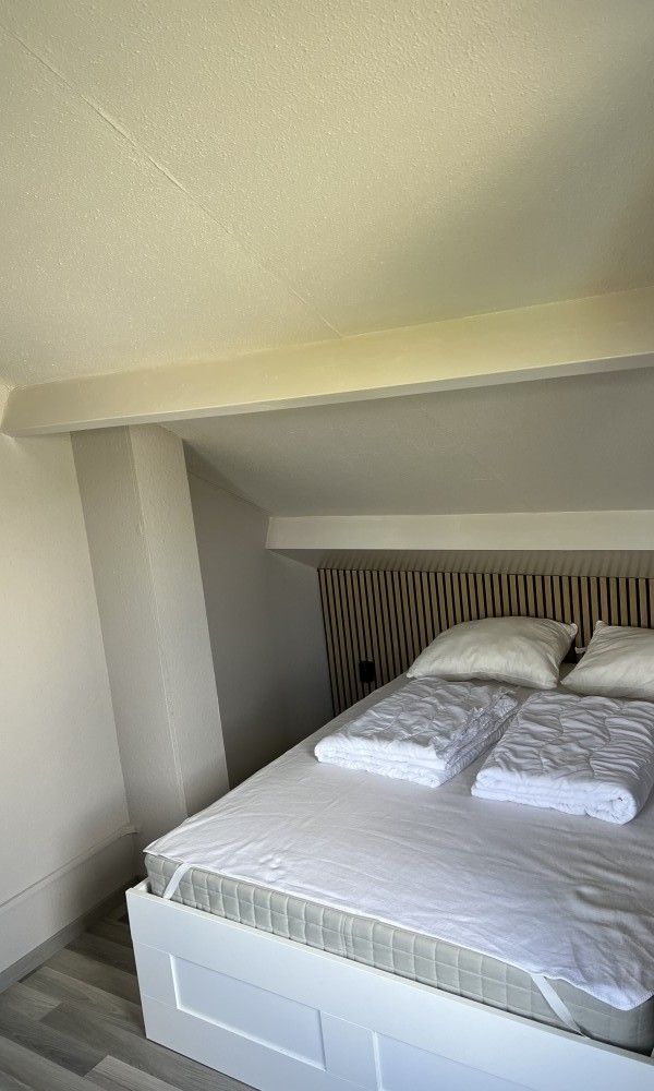 Sfeervolle slaapkamer in TXL Huisje 299, een vakantiehuis in De Cocksdorp, Texel, met een comfortabel bed en rustieke houten accenten.
