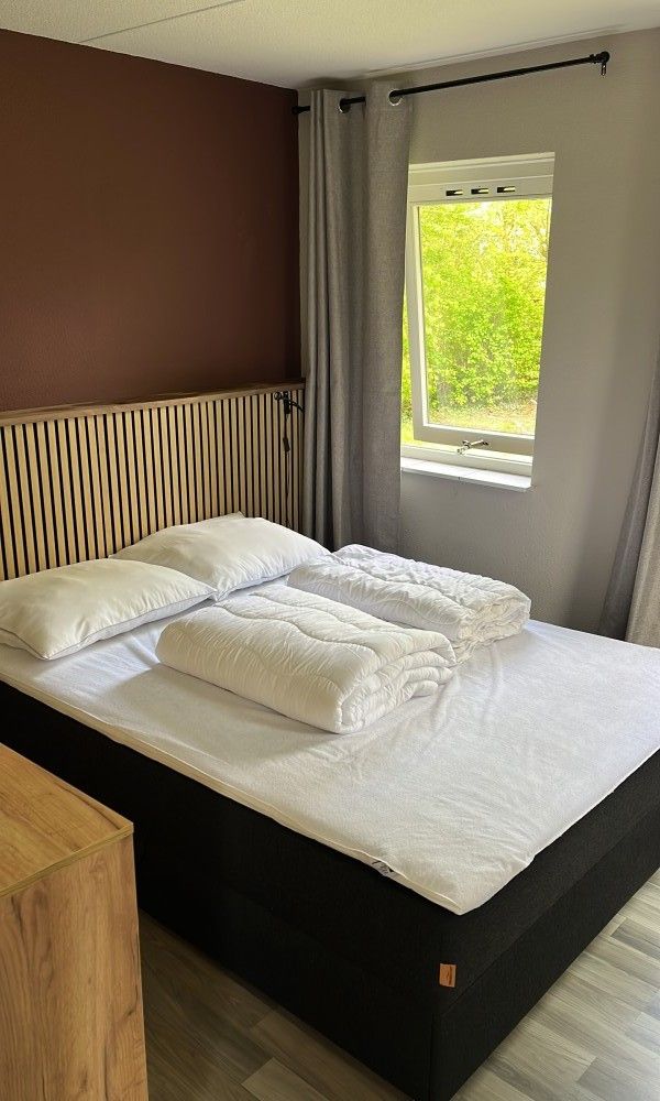 Sfeervolle slaapkamer in TXL Huisje 299, een vakantiehuis in De Cocksdorp, Texel. Gezellig interieur met uitzicht op groene natuur.