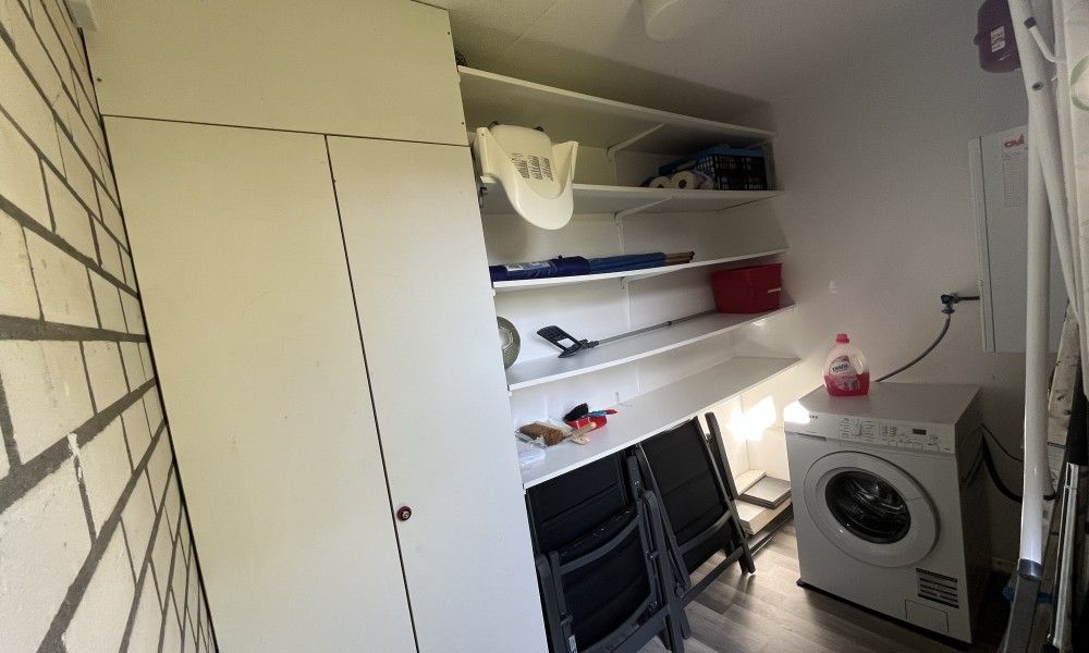 Praktische bijkeuken in TXL Huisje 299, vakantiehuis in De Cocksdorp, Texel, met wasmachine en opbergruimte voor een comfortabel verblijf.
