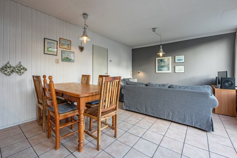 Gezellige woonkamer in Vakantiehuis Slufterhoek 114, De Cocksdorp, Texel, met comfortabele zithoek en eettafel.