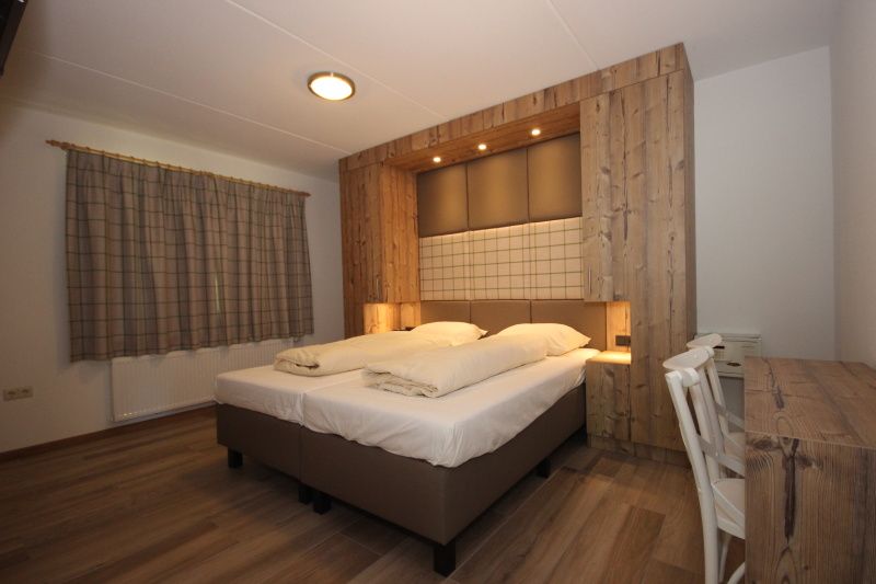 Stylish bedroom in Villa De Witte Hoek 138 conservatory, De Cocksdorp Texel, vacation home with wooden accents and cozy atmosphere.