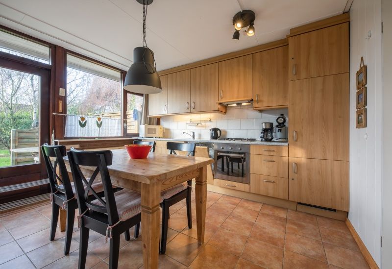 Ruime keuken van Vakantiehuis Slufterhoek 100 in De Cocksdorp, Texel met houten kasten.