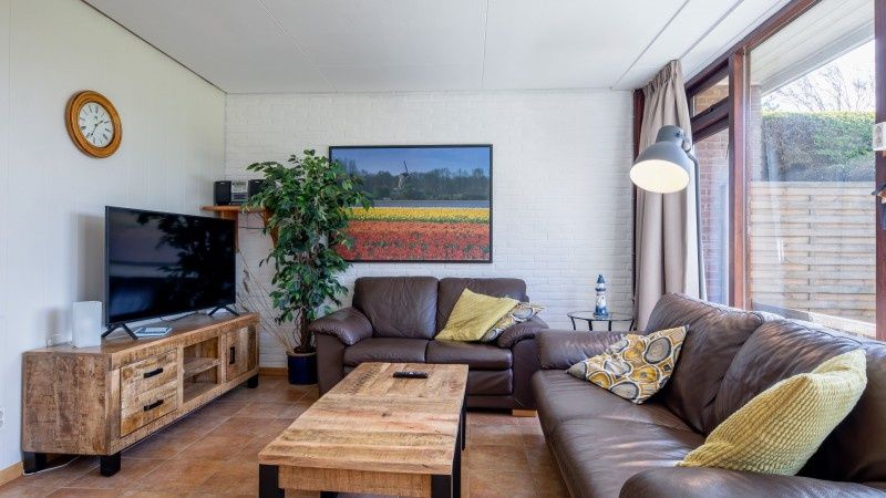 Stijlvolle zithoek in Vakantiehuis Slufterhoek 100, De Cocksdorp, Texel met grote ramen.