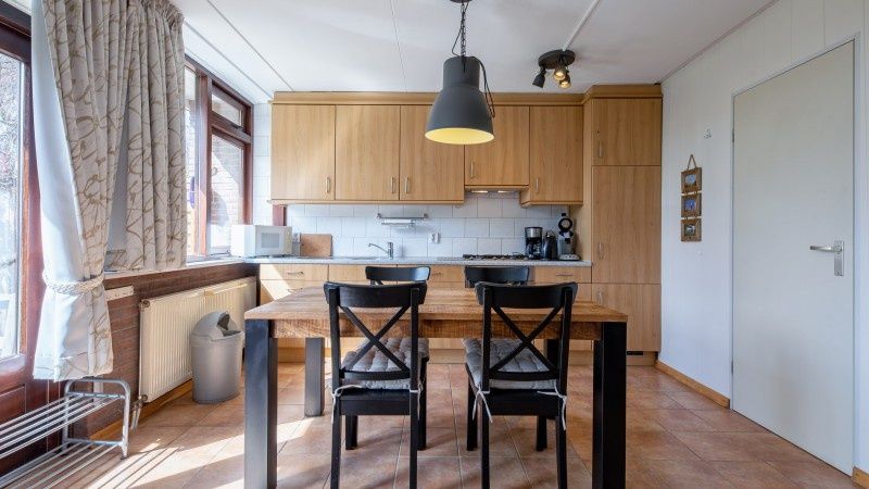 Eetkamer met houten tafel in Vakantiehuis Slufterhoek 100, De Cocksdorp, Texel.