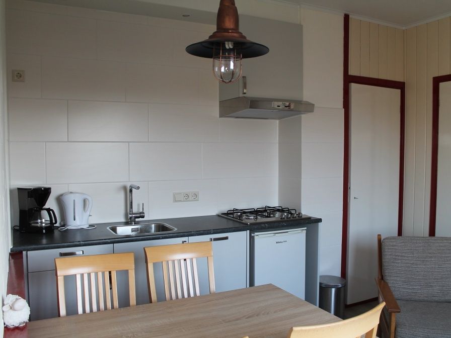Moderne keuken in vakantiehuis Onder de vuurtoren 115, De Cocksdorp, Texel met eethoek en kookfaciliteiten.