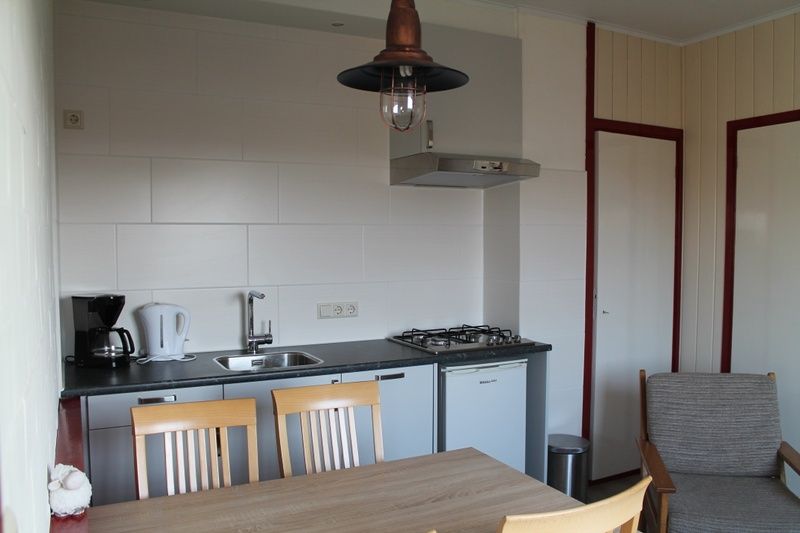 Praktische keuken in vakantiehuis Onder de vuurtoren 115, De Cocksdorp, Texel met moderne apparatuur en eethoek.