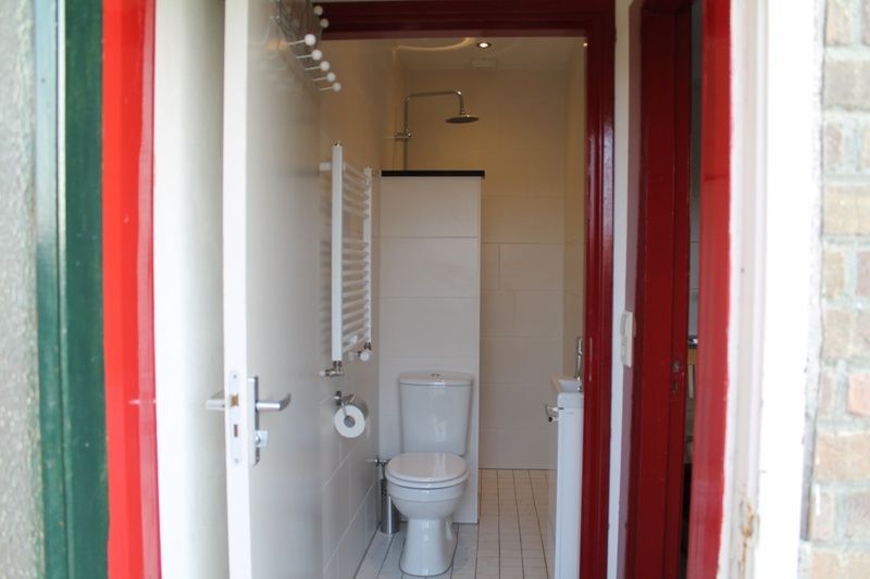Moderne badkamer in vakantiehuis Onder de vuurtoren 115, De Cocksdorp, Texel met douche en toilet.