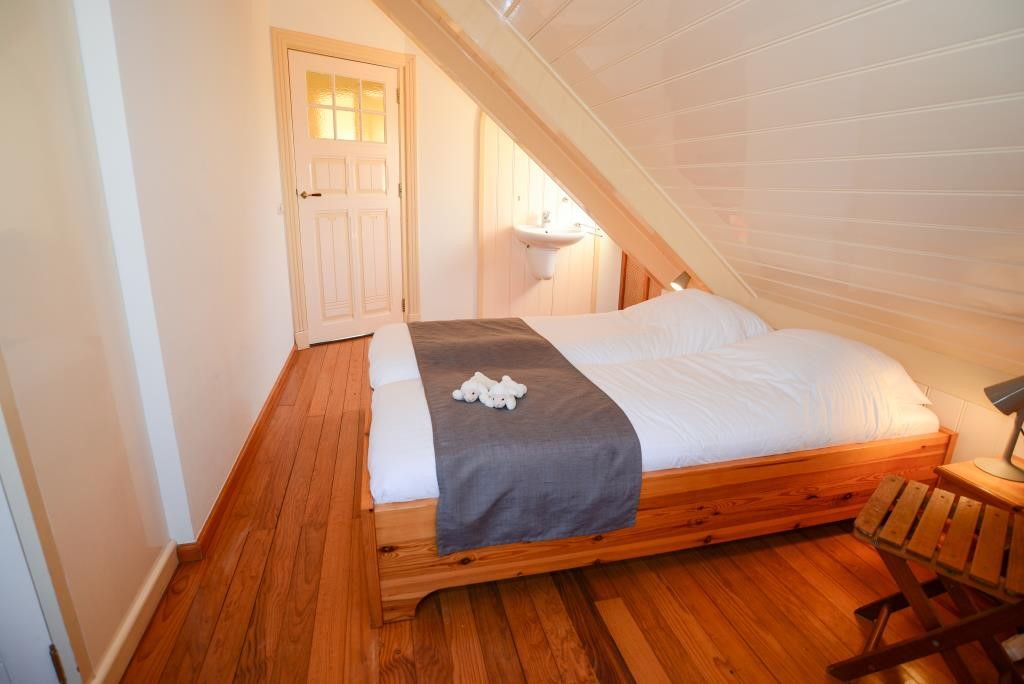 Gemuetliches Schlafzimmer in Velduil Ferienhaus De Cocksdorp Texel mit Holzdetails.