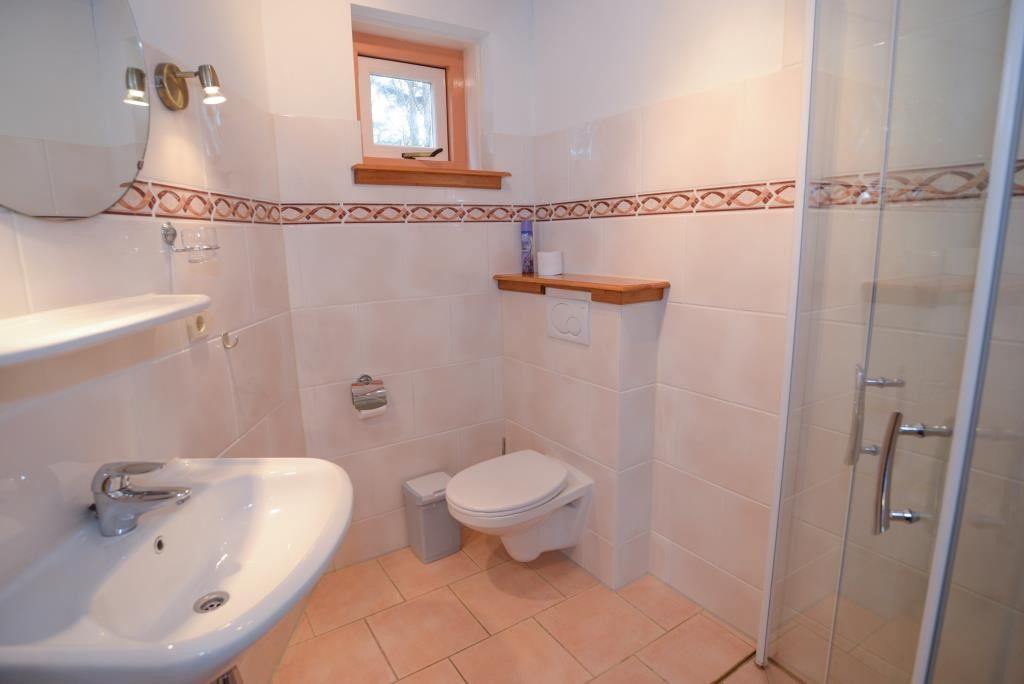 Modernes Badezimmer im Velduil Ferienhaus De Cocksdorp Texel mit Dusche und Toilette.