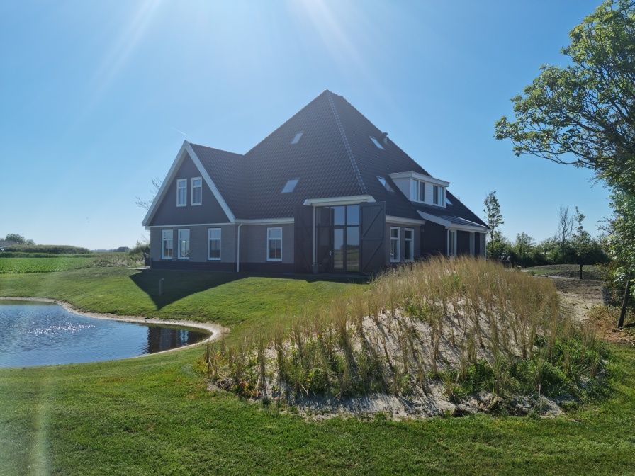 Ferienhaus De Muy in De Cocksdorp auf Texel mit Blick auf den Garten und den Teich.