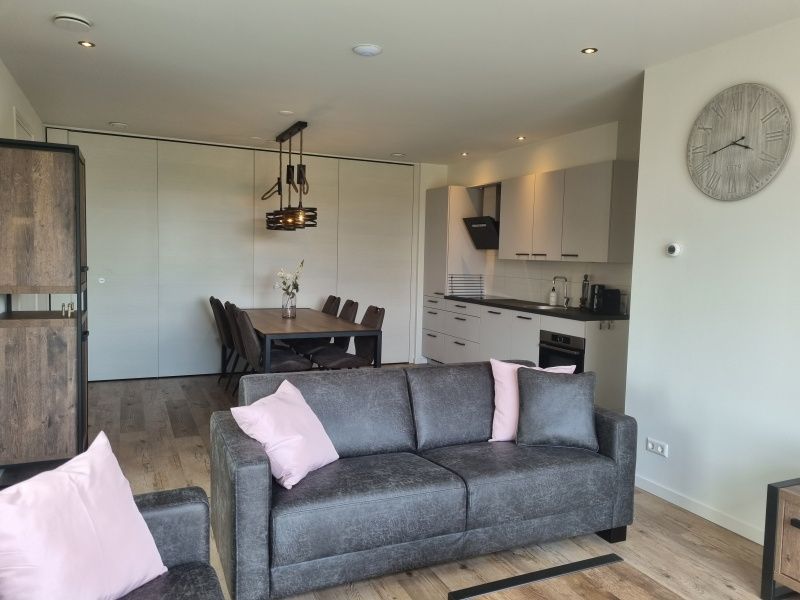 Ervaar comfort in de woonkamer van Vakantiehuis De Slufter in De Cocksdorp, Texel, met een moderne inrichting en eetruimte.