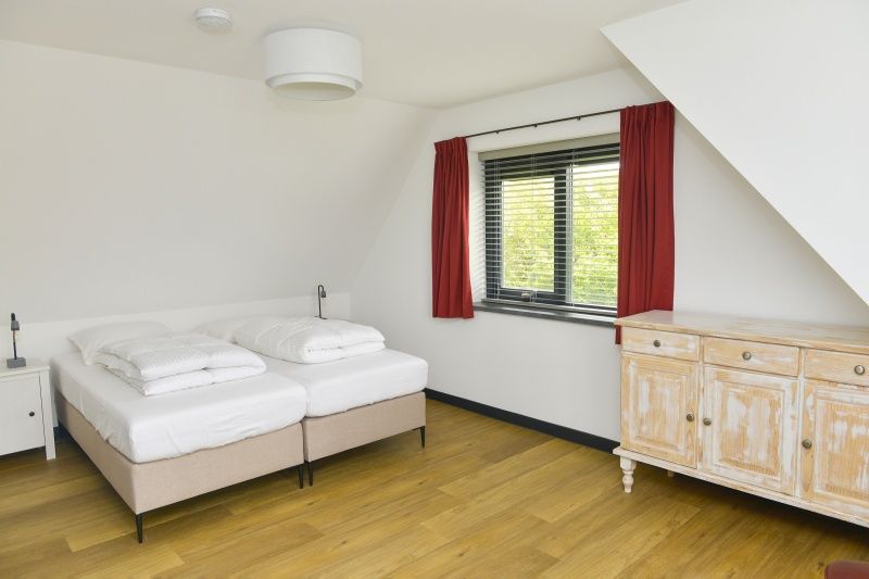 Lichte slaapkamer in De Postschipper vakantiewoning in De Cocksdorp, Texel, met moderne inrichting.