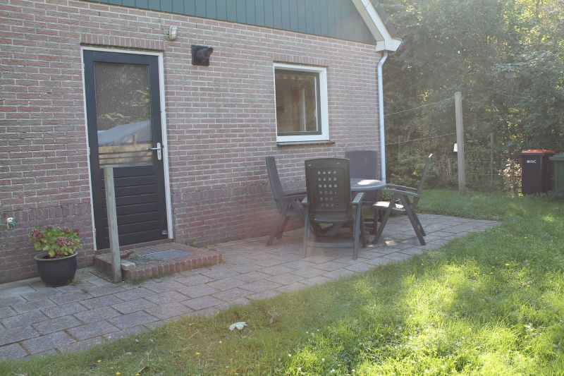 Terrace of Duin-/vuurtorenzicht detached vacation home in De Cocksdorp, Texel with garden chairs and table.