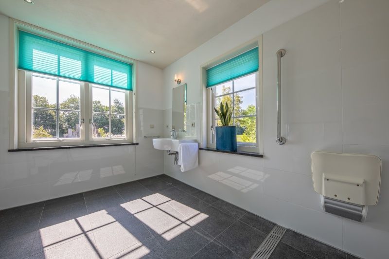 Lichte badkamer met grote ramen in Vakantiehuis Paal 86, De Cocksdorp, Texel.