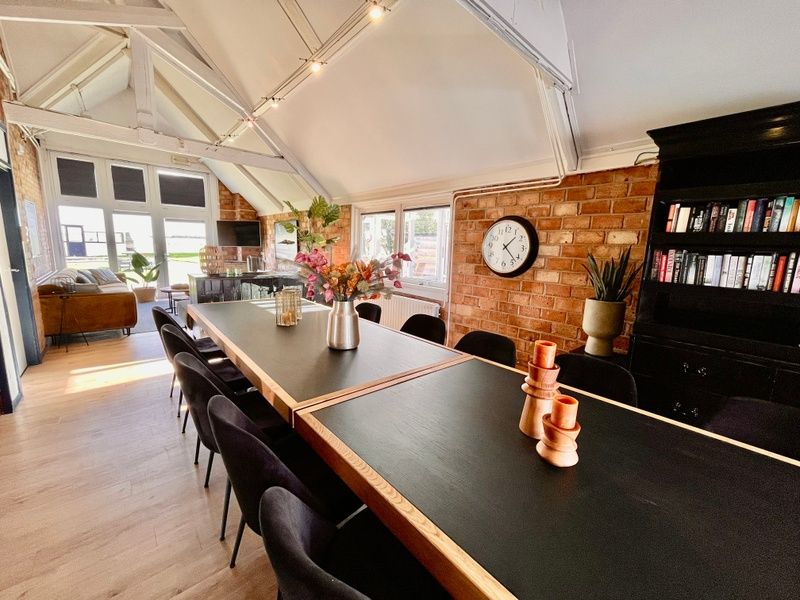 Lichte eetkamer in Noorderwind vakantiehuis, De Cocksdorp, Texel met grote tafel en uitzicht op de tuin.
