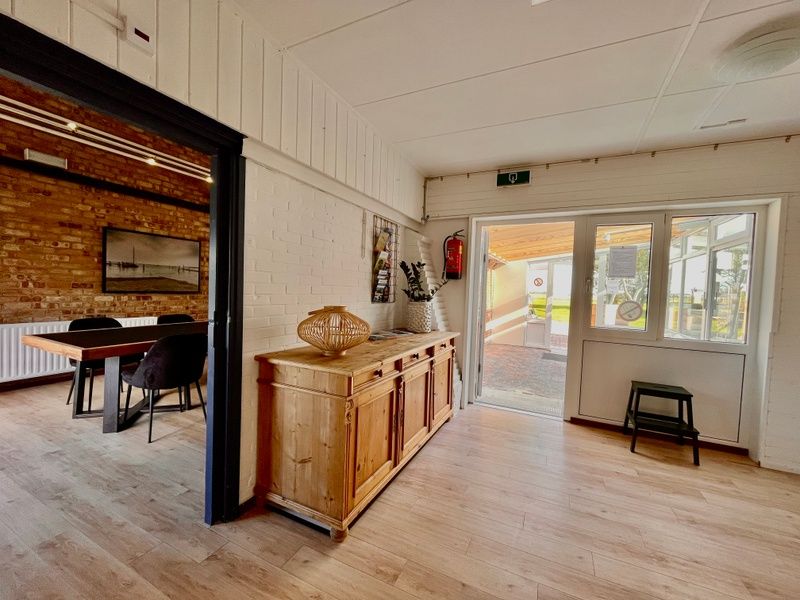 Entree van Noorderwind vakantiehuis, De Cocksdorp, Texel met houten kast en toegang tot terras.