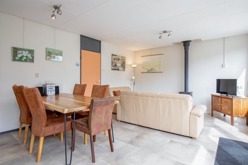 Ruime eetkamer in Vakantiehuis Slufterhoek 118, Texel, met houten tafel en comfortabele stoelen.