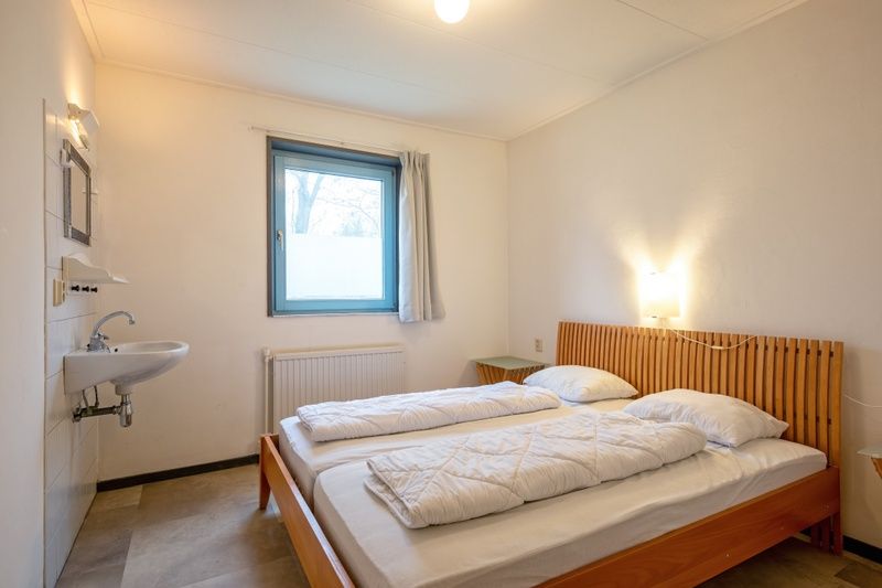 Slaapkamer met comfortabel tweepersoonsbed en natuurlijk licht in Vakantiehuis Slufterhoek 118, Texel.