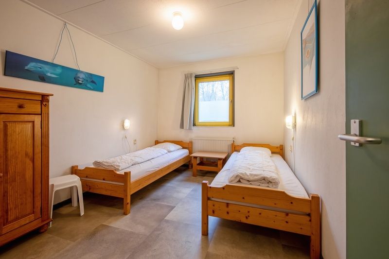 Slaapkamer met twee eenpersoonsbedden in Vakantiehuis Slufterhoek 118, Texel, ideaal voor kinderen.