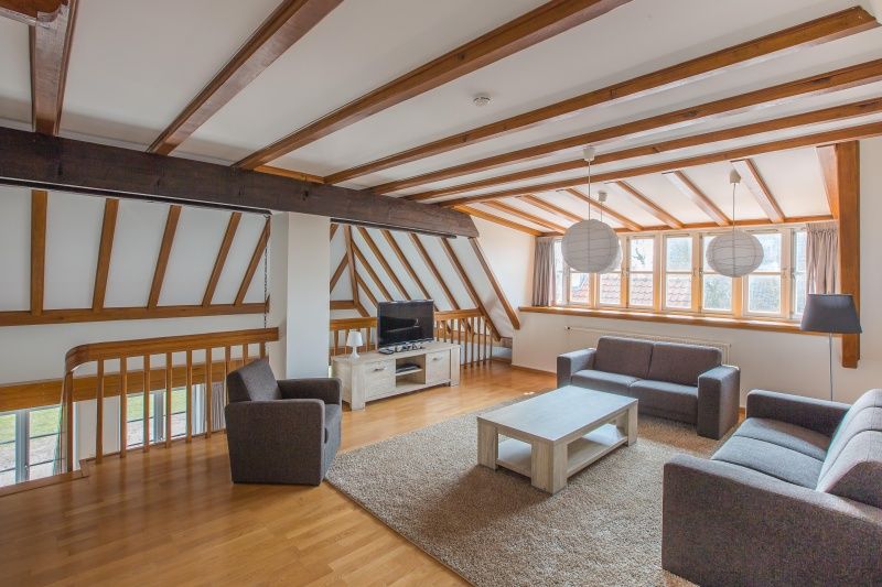 Ruime woonkamer in Type W vakantiehuis, De Cocksdorp Texel met houten balken en veel licht.