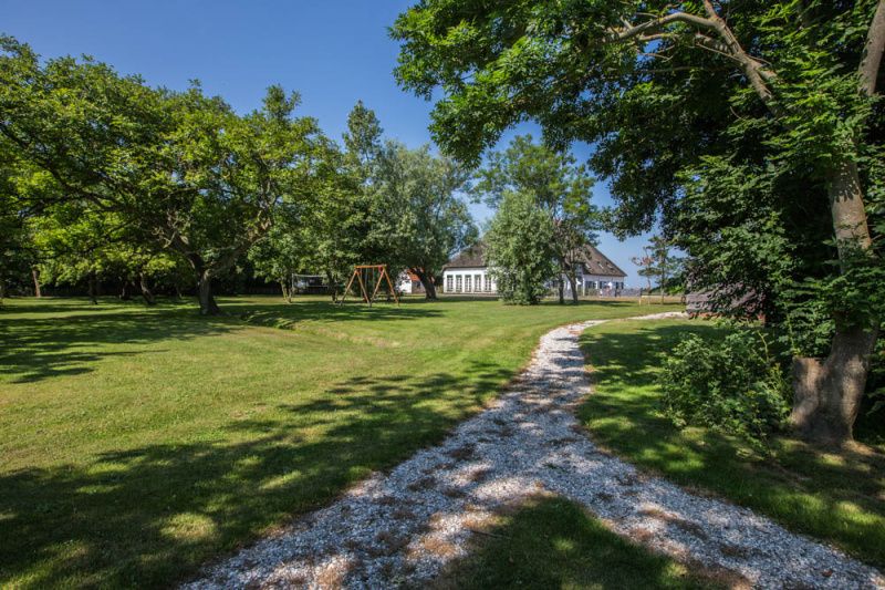 Uitgestrekte tuin rondom Type W vakantiehuis in De Cocksdorp Texel met speeltoestellen.