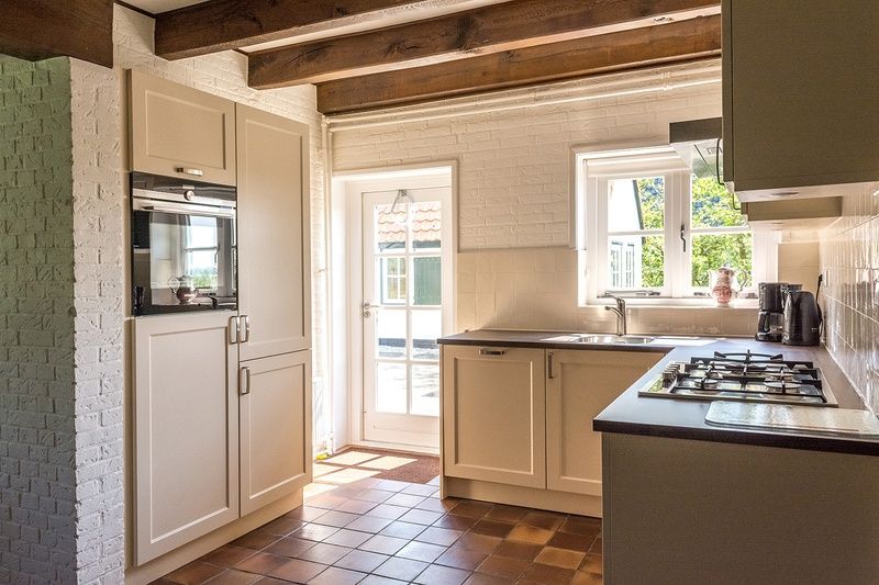 Moderne keuken in vakantiehuis Type W, De Cocksdorp Texel met uitzicht op de tuin.