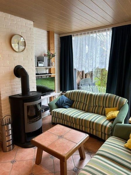 Lichte woonkamer van Vakantiehuis Slufterhoek 128 in De Cocksdorp, Texel met grote ramen.